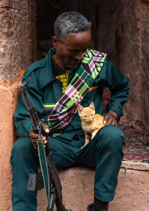 Ethiopian soldier with a kitten protecting the rock-hewn church, Amhara Region, Lalibela, Ethiopia