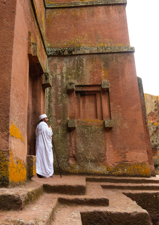 Ethiopian orthodox priest in front of a rock-hewn church, Amhara Region, Lalibela, Ethiopia
