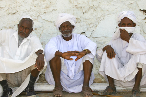 Eritrean musilim men sit along a wall, Anseba, Keren, Eritrea