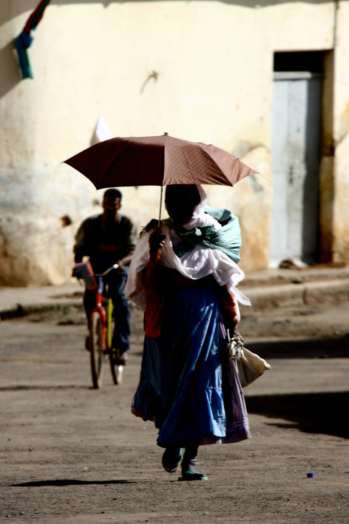 Eritrean woman with an umbrella in the street, Central Region, Asmara, Eritrea