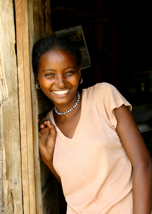 Smiling eritrean girl leaning on a door, Northern Red Sea, Massawa, Eritrea