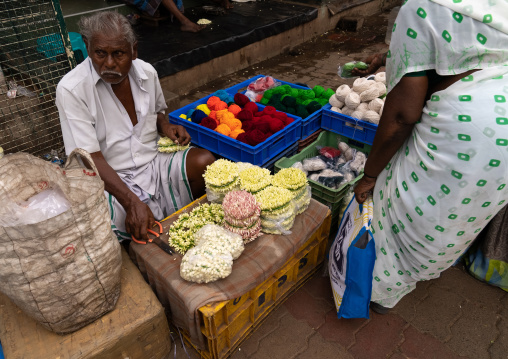 Indian man selling flowers near a temple, Tamil Nadu, Madurai, India