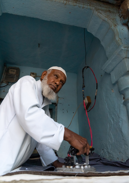 Old indian muslim man ironing clothes, Rajasthan, Ramgarh Shekhawati, India