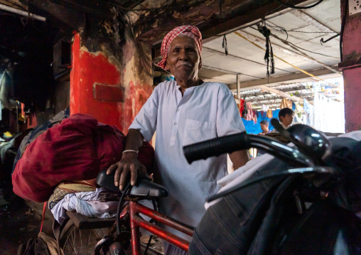 Laundry Worker with bicycle in Dhobi Ghat, Maharashtra state, Mumbai, India