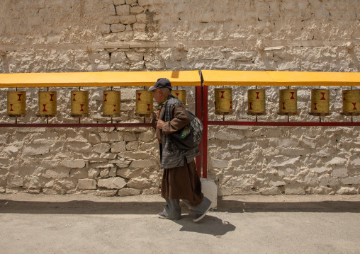 Pilgrim in front of prayer wheels in Lamayuru Monastery, Ladakh, Khalatse, India