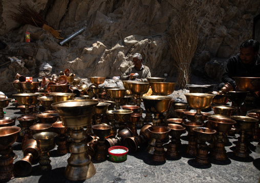 Pilgrim cleaning oil lamps in Shey Monastery, Ladakh, Shey, India