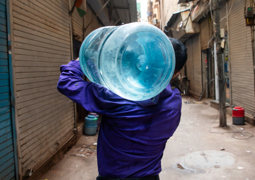 Man carrying plastic bottled water in old Delhi, Delhi, New Delhi, India