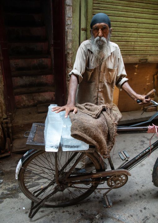 Indian man carrying ice on his bicycle in old Delhi, Delhi, New Delhi, India