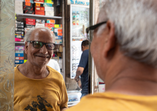 Smiling indian man choosing eyeglasses in an optics, Delhi, New Delhi, India