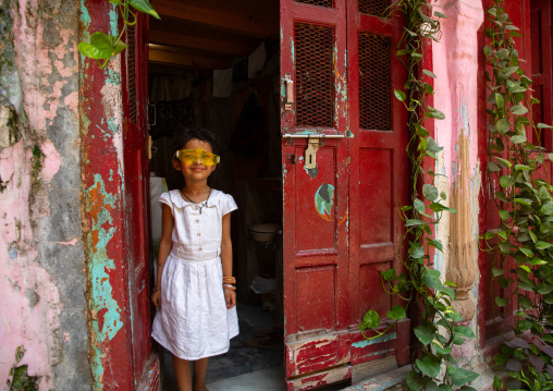 Indian girl standing in a red door in old Delhi, Delhi, New Delhi, India