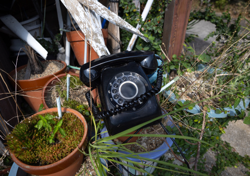 Old black telephone with a dial in a dump, Kyushu region, Arita, Japan