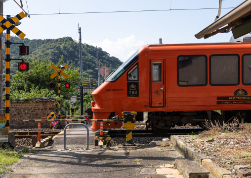 Red train passing in a railway crossing, Kyushu region, Arita, Japan