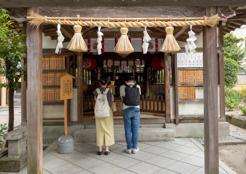 Japanese people praying at Kushida-jinja shinto shrine, Kyushu region, Fukuoka, Japan