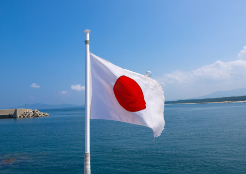 Japanese flag on a ferry in front of the sea, Kyushu region, Fukuoka, Japan