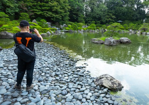 Tourist taking pictures in Ohori Park Japanese Garden, Kyushu region, Fukuoka, Japan