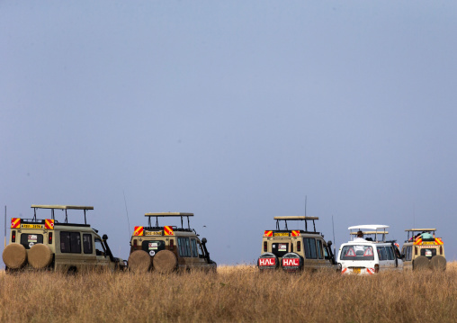 Tourists in cars watching animals during a safari in the savanna, Rift Valley Province, Maasai Mara, Kenya