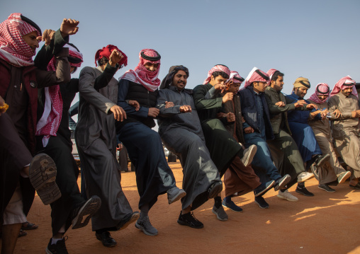 Saudi men dancing in line during King Abdul Aziz Camel Festival, Riyadh Province, Rimah, Saudi Arabia