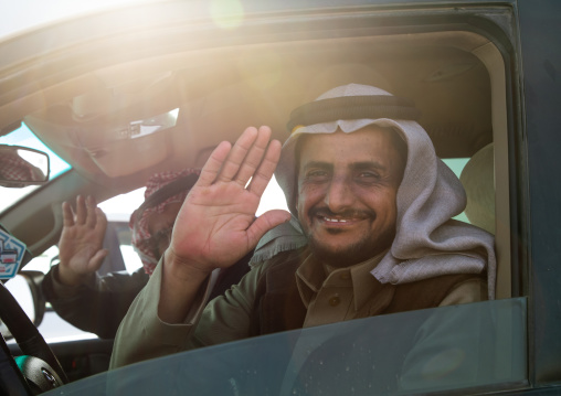 Smiling Saudi men in a car in King Abdul Aziz Camel Festival, Riyadh Province, Rimah, Saudi Arabia
