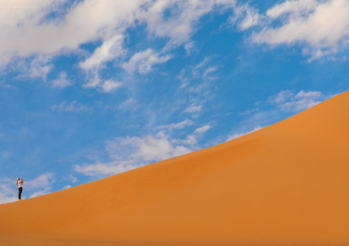Tourist taking picture at the foot of a Rub al Khali dune, Najran Province, Thar, Saudi Arabia