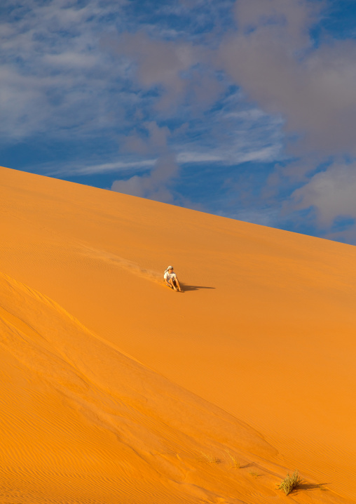 Tourist making sandboarding in the Rub al Khali dunes desert, Najran Province, Thar, Saudi Arabia