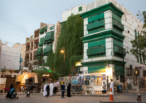 Tourists in front of old houses with wooden mashrabiya in al-Balad quarter, Mecca province, Jeddah, Saudi Arabia