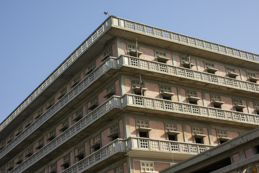 Rows of weathered balconies line the upper corner of the abandoned Saint George Hotel against a clear blue sky, Beirut Governorate, Beirut, Lebanon