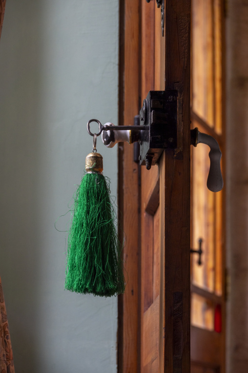 A green silk tassel dangles from an antique key in an old wooden door lock at the historic Palmyra Hotel, Baalbek-Hermel Governorate, Baalbek, Lebanon