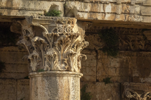 A weathered Corinthian column capital displays intricate acanthus leaf carvings at the ancient Roman ruins, Baalbek-Hermel Governorate, Baalbek, Lebanon