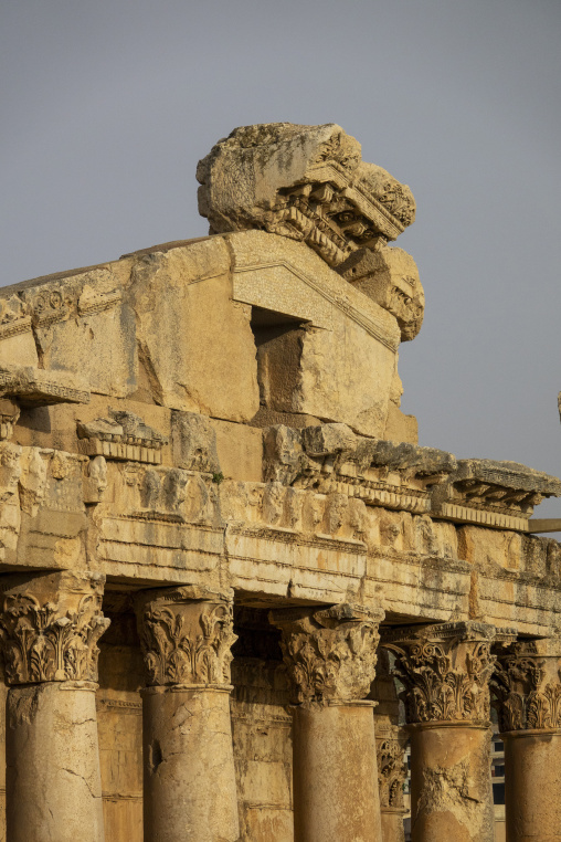 Carved stone pediments and column capitals crown the ruins of an ancient Roman temple against a clear sky, Baalbek-Hermel Governorate, Baalbek, Lebanon