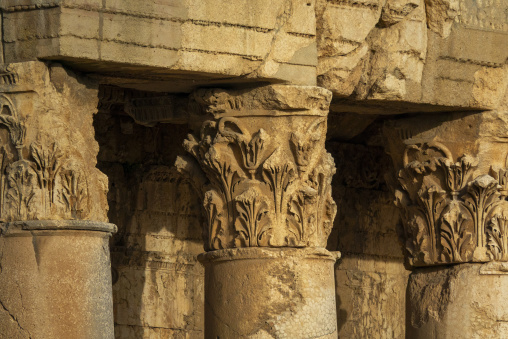 A carved stone capital features ornate ram head decoration among the ruins of the ancient Roman temple, Baalbek-Hermel Governorate, Baalbek, Lebanon