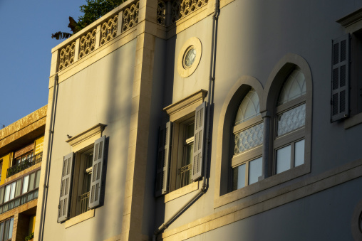 A restored heritage building showcases arched windows with wooden shutters and ornate stone carvings, Beirut Governorate, Beirut, Lebanon