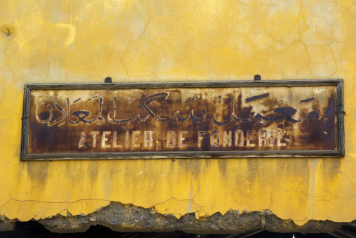 A rusted bilingual sign reading Atelier de Fonderie marks the old foundry workshop wall of the historic Beirut-Damascus railway workshops, Beqaa Governorate, Rayak, Lebanon