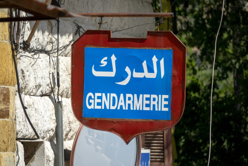 A bilingual red and blue sign marks the entrance of a gendarmerie police station, North Governorate, Tripoli, Lebanon
