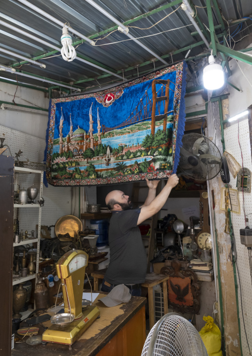 Seller hanging a carpet with Hagia Sophia mosque, North Governorate, Tripoli, Lebanon