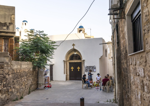 People relaxing in front of St Georges greek orthodox church, North Governorate, Tripoli, Lebanon