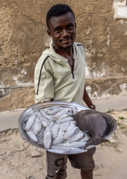 Man in the street showing the squids he catched, Nampula Province, Island of Mozambique, Mozambique