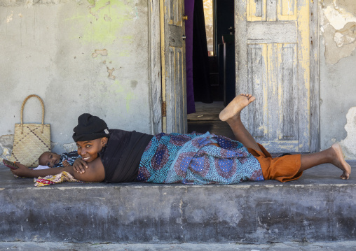 Mother and baby resting in front of their house, Nampula Province, Island of Mozambique, Mozambique