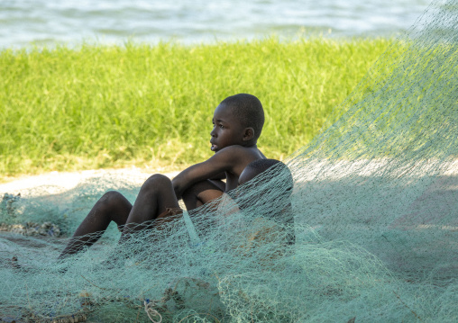 Boys resting on fishing nets, Nampula Province, Island of Mozambique, Mozambique