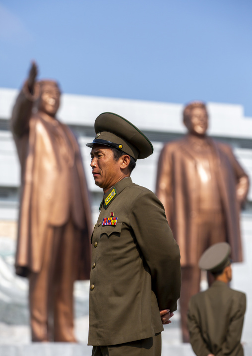 Soldiers in front of the statues of the Leaders in the Grand monument on Mansu hill, DGC, Pyongyang, North Korea