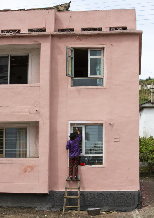 North korean woman painting a window, South Hamgyong, Hamhung, North Korea