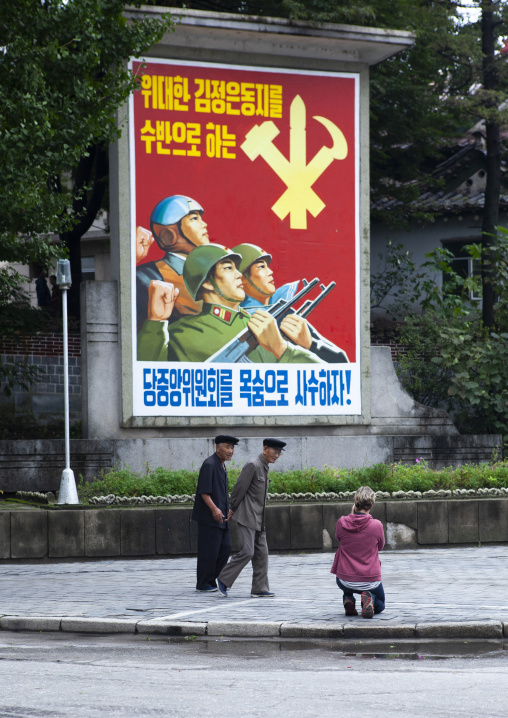 Tourist taking a picture of a propaganda billboard, North Hwanghae, Kaesong, North Korea