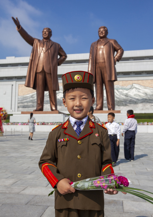 Boy in army uniform paying respect to the statues of the Leaders in Grand monument, DGC, Pyongyang, North Korea
