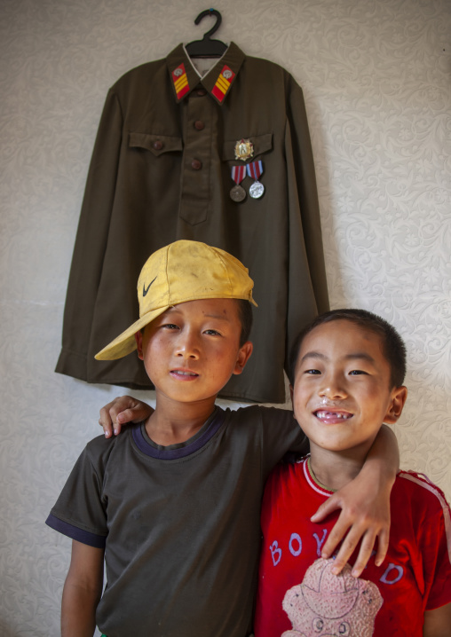 Children near a military jacket hung in a house, South Pyongan, Chonsam Cooperative Farm, North Korea