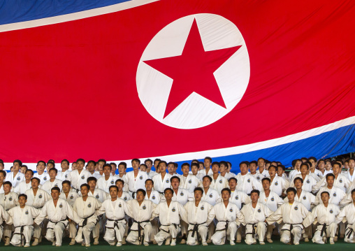 Taekwondo team in front of a giant flag during the Arirang mass games, DGC, Pyongyang, North Korea