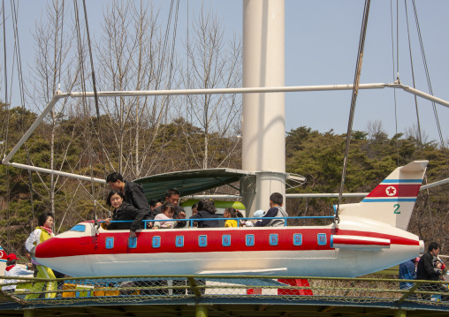 People having fun on a plane attraction in Taesongsan funfair, DGC, Pyongyang, North Korea