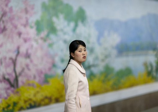North Korean woman in front of a fresco in Puhung metro station, DGC, Pyongyang, North Korea