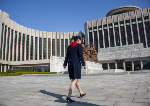 North Korean pioneer in front of Mangyongdae children's palace statue, DGC, Pyongyang, North Korea