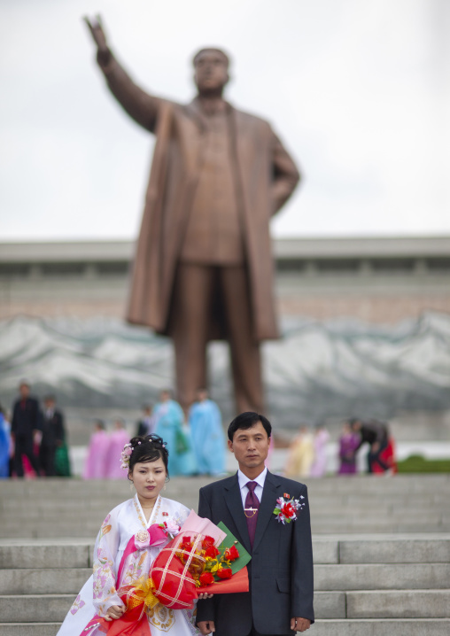 Couple celebrating their wedding in front of Kim il Sung statue in Mansudae, DGC, Pyongyang, North Korea