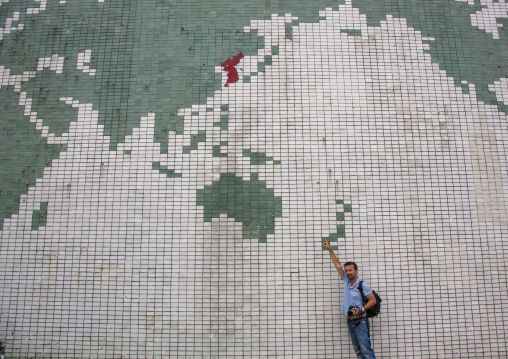 Tourist in front of a world map in Songdowon children's camp, Kangwon Province, Wonsan, North Korea