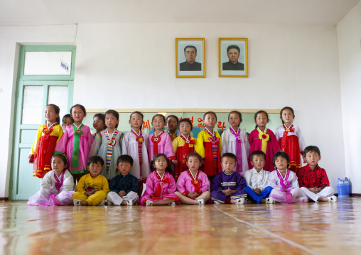 Children under leaders portraits in a primary school, South Pyongan, Chongsan-ri Cooperative Farm, North Korea
